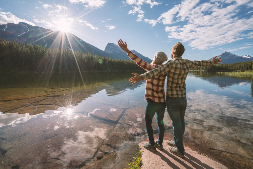 CAS Resilienz und Positive Psychologie Mann und Frau ausgestreckte Arme am Wasser